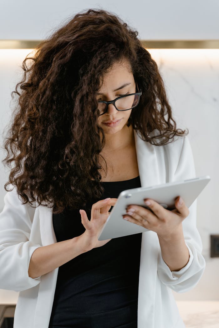 Focused young woman using a tablet in a modern indoor setting.